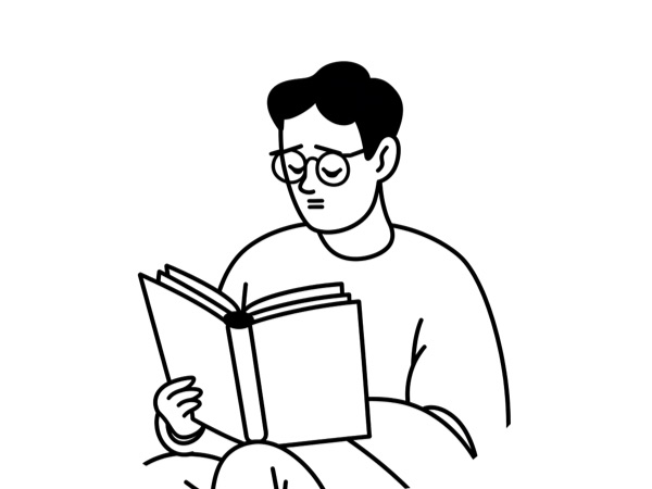 A man sits, reading a book